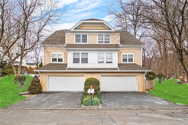 view of front of home featuring a garage, driveway, a shingled roof, and a front lawn