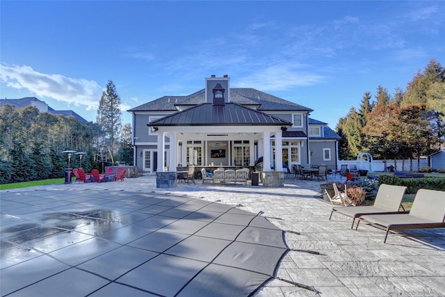 rear view of property featuring french doors, a mountain view, and a patio area