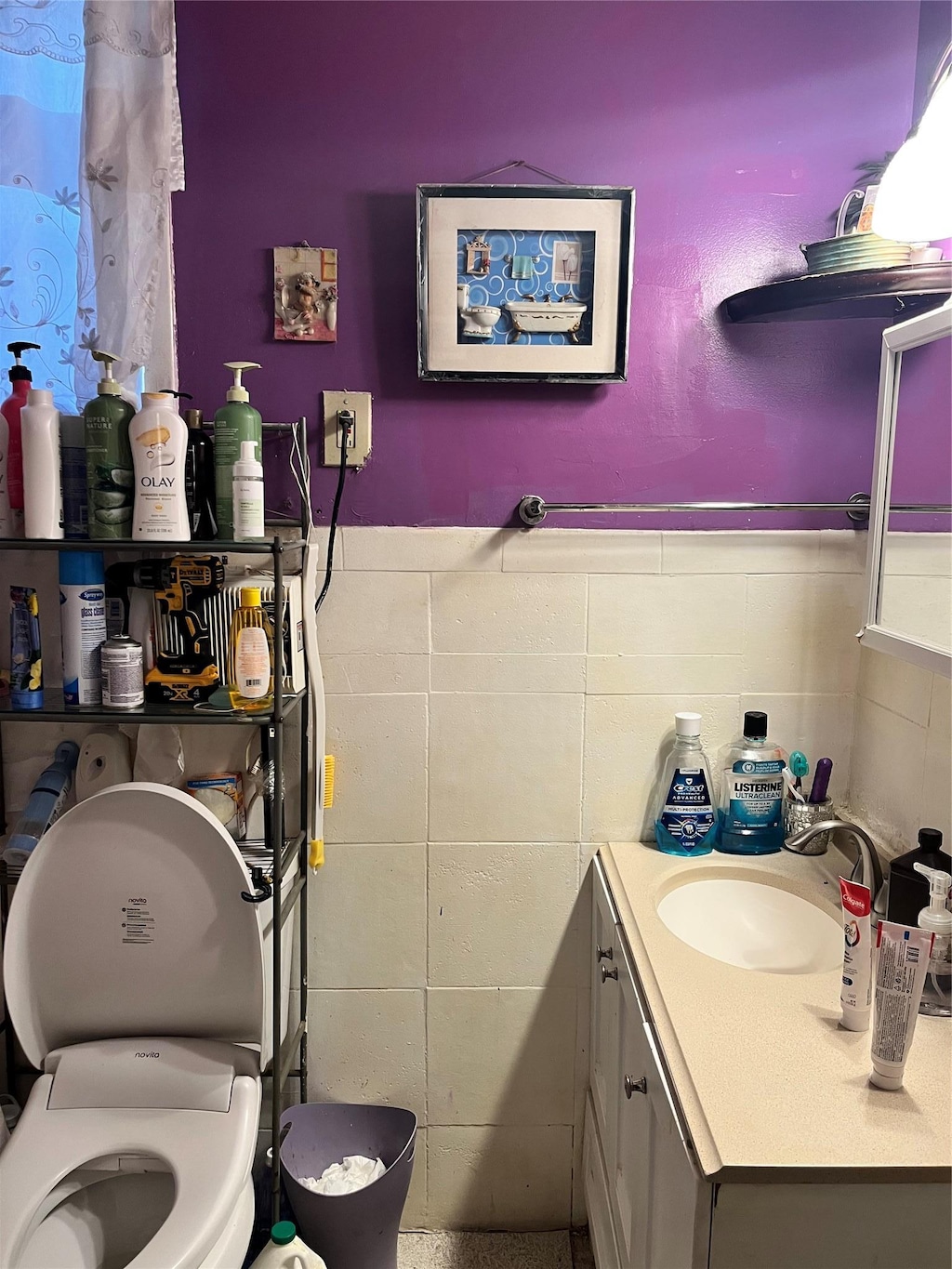 bathroom featuring vanity, tile walls, and toilet