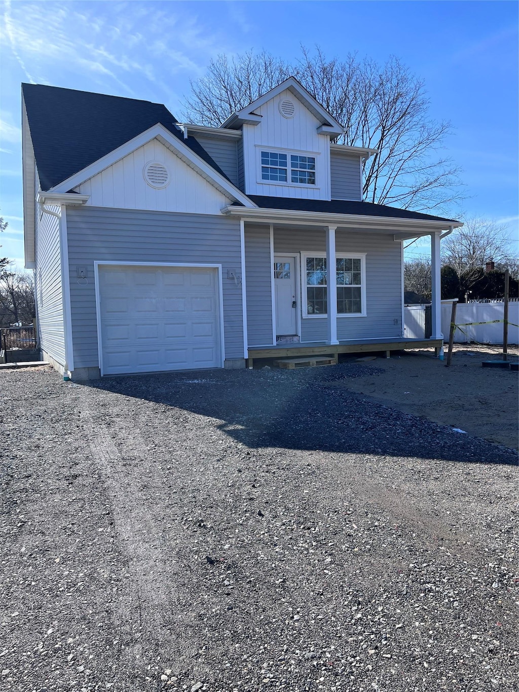 traditional home with a porch, driveway, and a garage