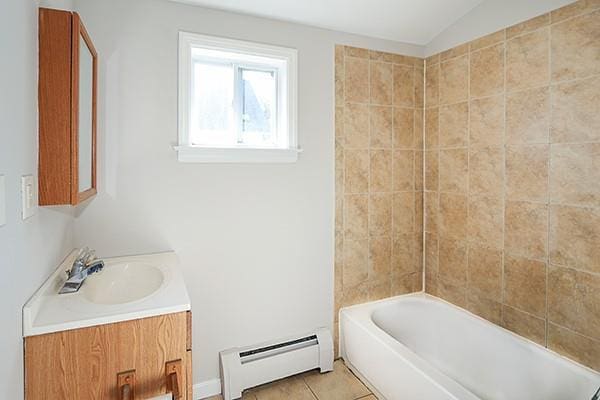 bathroom featuring vaulted ceiling, a baseboard radiator, tile patterned flooring, and vanity