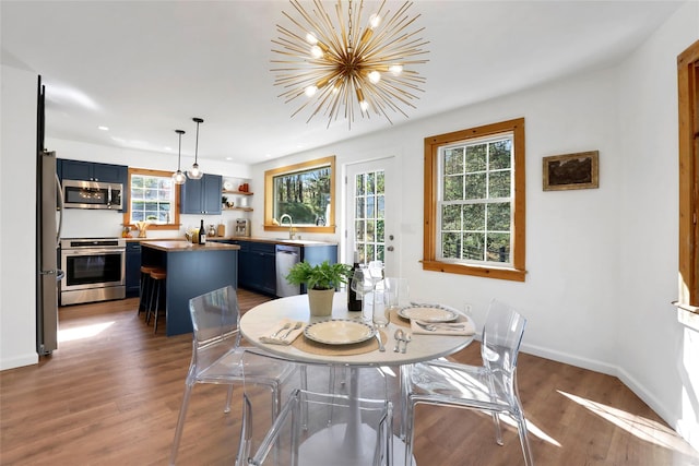 dining space featuring sink, an inviting chandelier, and dark hardwood / wood-style floors