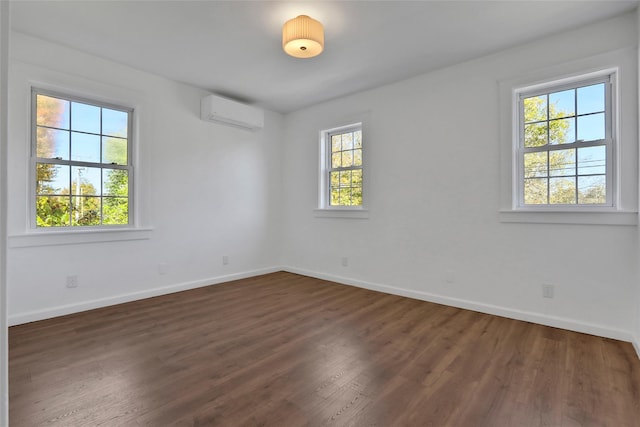 spare room with dark hardwood / wood-style floors and a wall unit AC