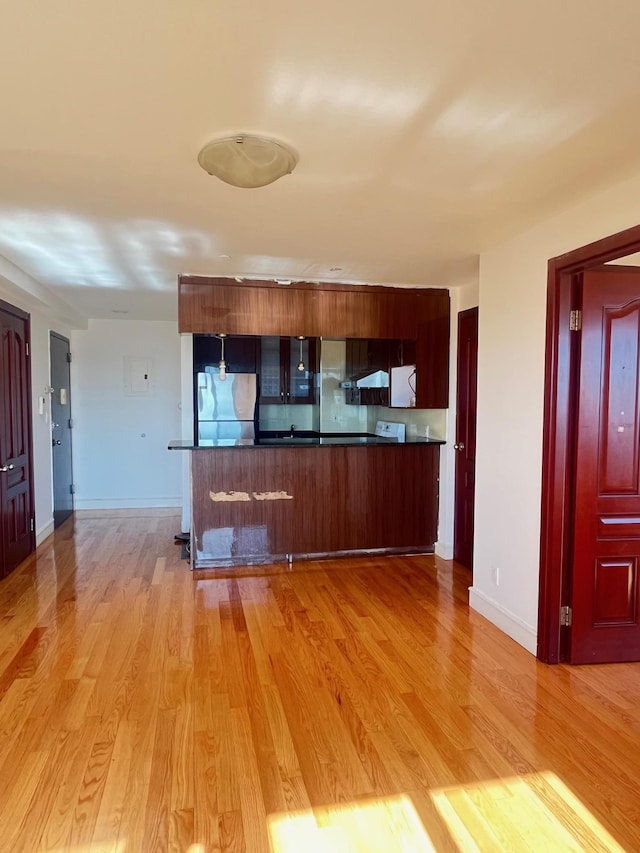 kitchen featuring light hardwood / wood-style flooring, extractor fan, stainless steel fridge, and kitchen peninsula