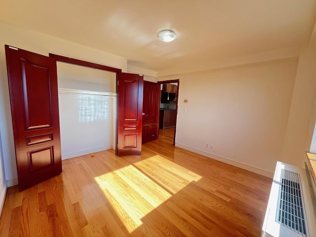 unfurnished bedroom featuring light hardwood / wood-style floors and a closet