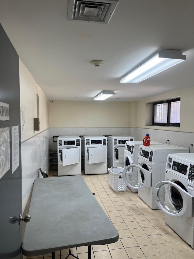 laundry room featuring washing machine and dryer and light tile patterned floors