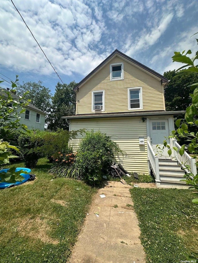 rear view of property with a lawn