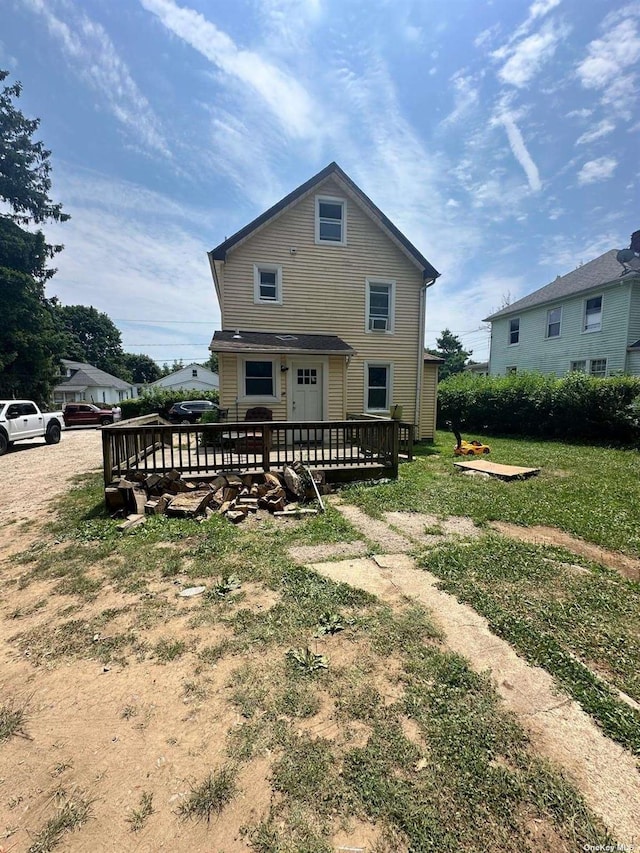 rear view of house with a wooden deck and a yard