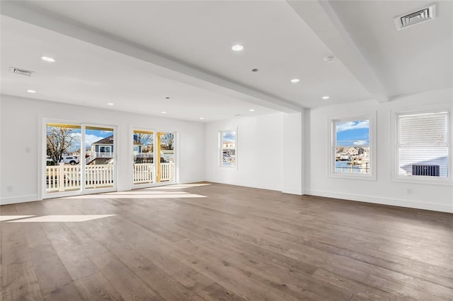 unfurnished living room featuring wood-type flooring and beamed ceiling