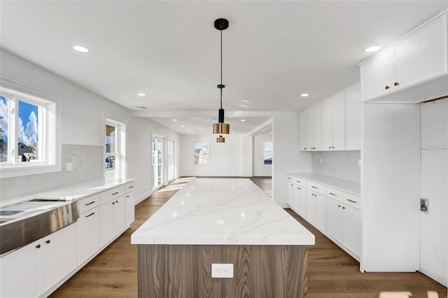 kitchen featuring hanging light fixtures, white cabinets, and a kitchen island