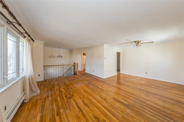 unfurnished room featuring crown molding, wood-type flooring, ceiling fan, and baseboard heating