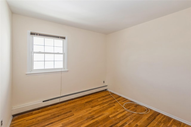 unfurnished room featuring wood-type flooring and baseboard heating