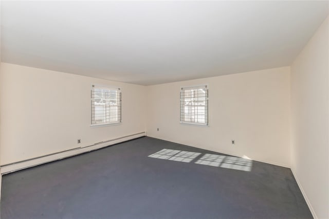 unfurnished room featuring a baseboard heating unit and a wealth of natural light