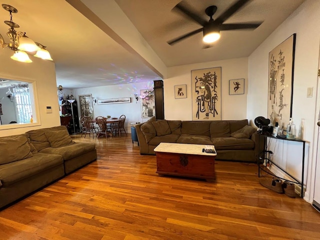 living room with ceiling fan with notable chandelier and wood finished floors