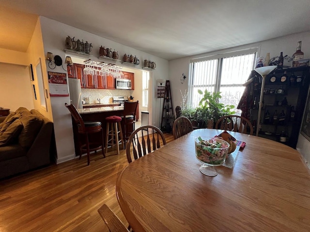 dining area with a bar and wood finished floors