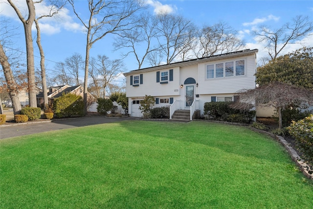 split foyer home featuring a front lawn and a garage