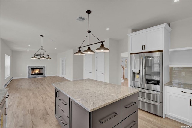 kitchen featuring stainless steel refrigerator with ice dispenser, a center island, gray cabinetry, and white cabinets