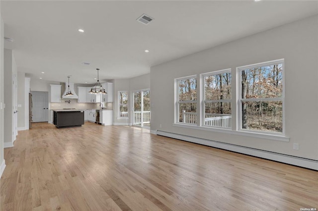 unfurnished living room with a baseboard radiator and light hardwood / wood-style floors