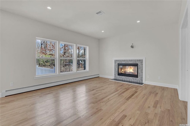 unfurnished living room featuring light hardwood / wood-style flooring and a baseboard radiator