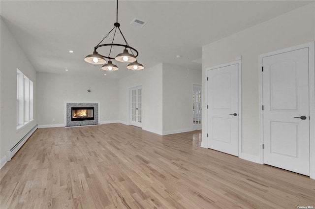 unfurnished living room with light hardwood / wood-style floors and baseboard heating