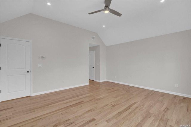 empty room with vaulted ceiling, ceiling fan, and light hardwood / wood-style floors