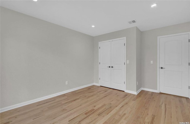 unfurnished bedroom with a closet and light wood-type flooring