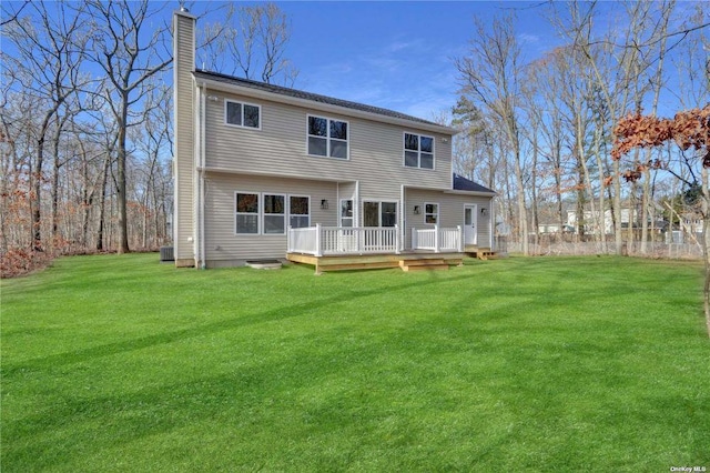 back of house with a wooden deck and a lawn