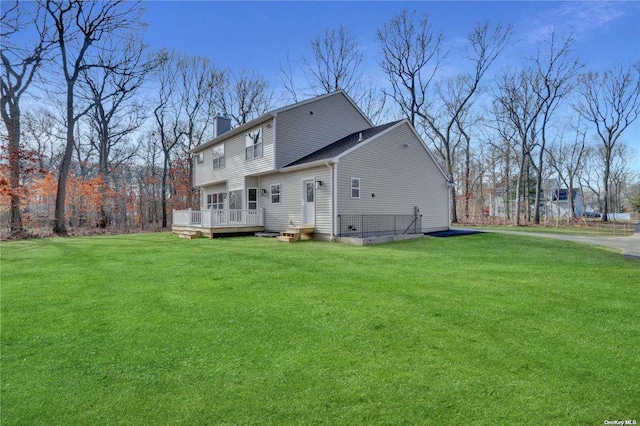 rear view of property with a yard and a deck