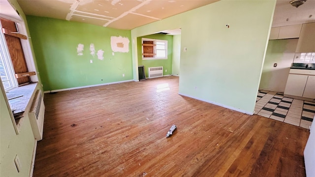 unfurnished living room featuring radiator and light hardwood / wood-style floors