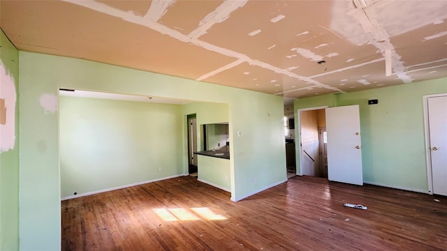 unfurnished room with dark wood-type flooring