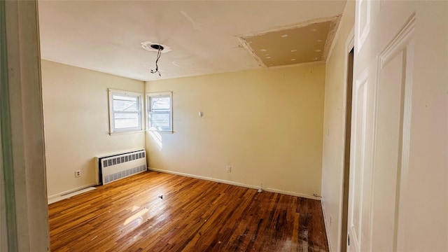 empty room featuring radiator and wood-type flooring