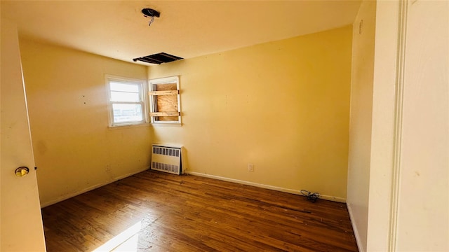 unfurnished room with radiator and dark wood-type flooring