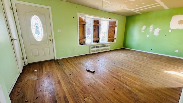 foyer entrance featuring radiator heating unit and hardwood / wood-style floors