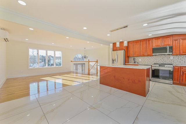 kitchen with decorative light fixtures, a wall mounted AC, decorative backsplash, a center island, and stainless steel appliances