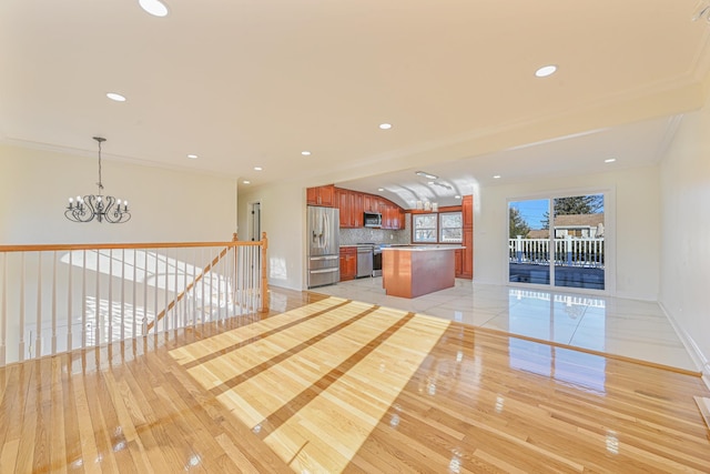 interior space with ornamental molding, a chandelier, and light hardwood / wood-style floors