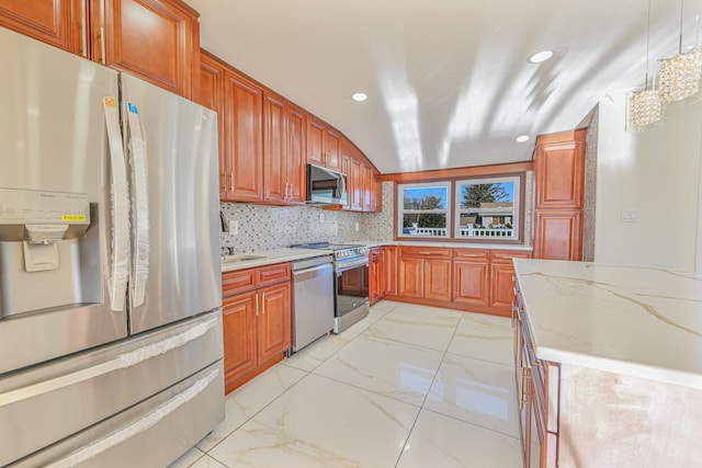 kitchen featuring backsplash, decorative light fixtures, light stone countertops, and appliances with stainless steel finishes