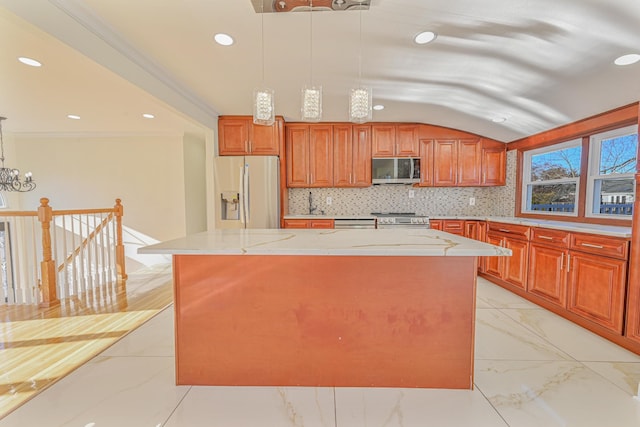 kitchen with pendant lighting, stainless steel appliances, crown molding, and a kitchen island