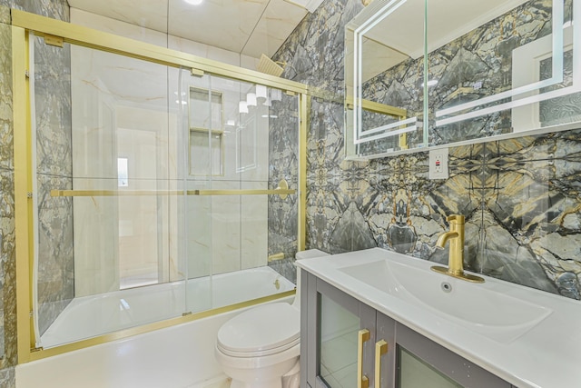 full bathroom featuring vanity, tile walls, toilet, and combined bath / shower with glass door