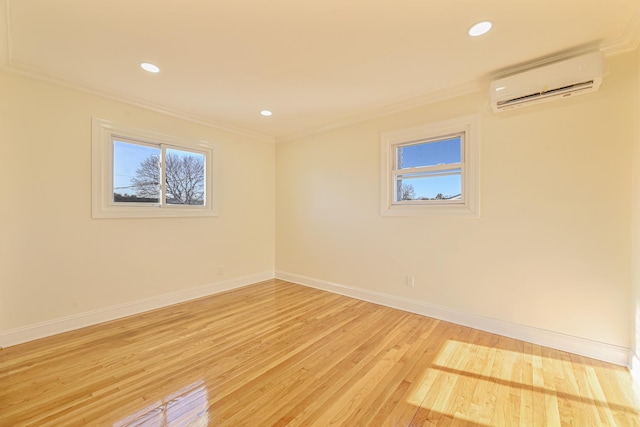 unfurnished room with ornamental molding, a wall mounted air conditioner, and light wood-type flooring