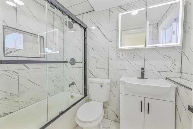 full bathroom featuring enclosed tub / shower combo, vanity, and toilet