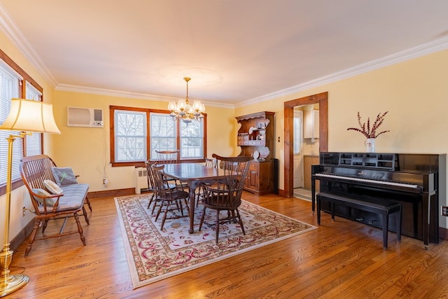 dining space featuring a wall mounted air conditioner, radiator heating unit, hardwood / wood-style flooring, crown molding, and an inviting chandelier