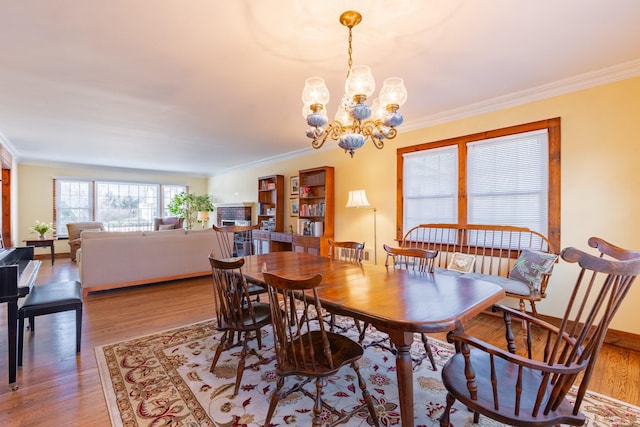 dining space featuring ornamental molding and light hardwood / wood-style floors