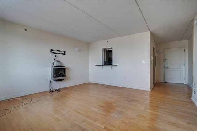 unfurnished room with a textured ceiling and light hardwood / wood-style flooring