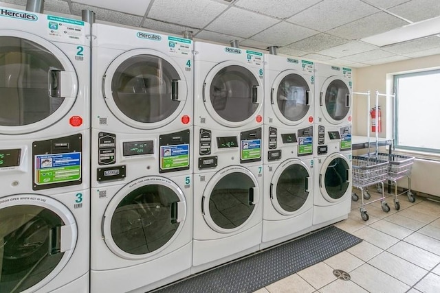 laundry room featuring stacked washing maching and dryer, light tile patterned floors, and washing machine and dryer