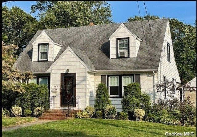 cape cod house featuring a front lawn