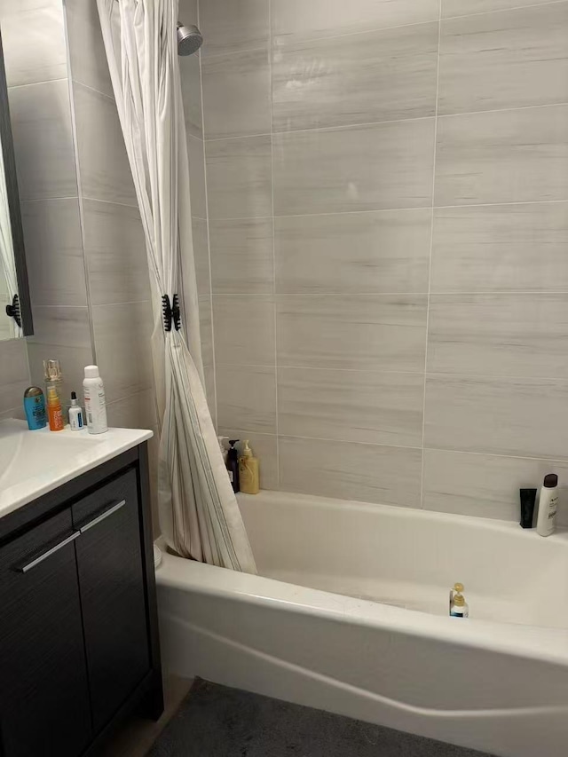 bathroom featuring shower / tub combo with curtain, vanity, and tile walls