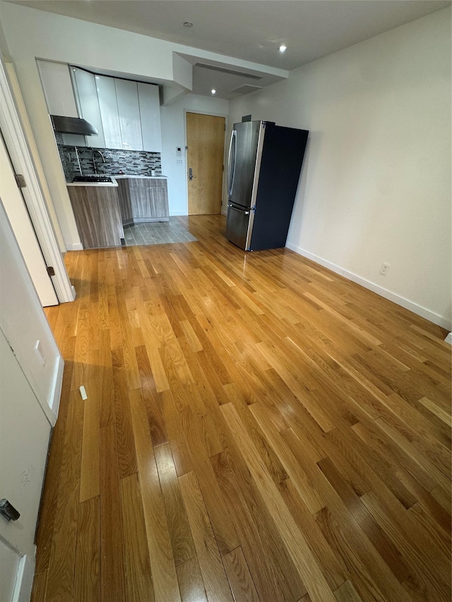 interior space featuring a sink, light wood-style flooring, and baseboards