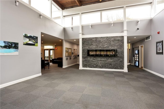 unfurnished living room featuring a fireplace and dark colored carpet