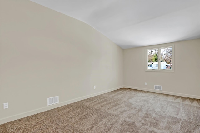 empty room featuring lofted ceiling and carpet