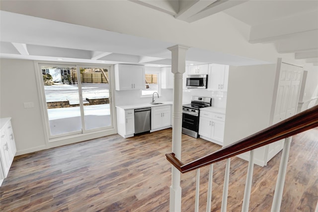 kitchen featuring stainless steel appliances, light hardwood / wood-style floors, sink, and white cabinets